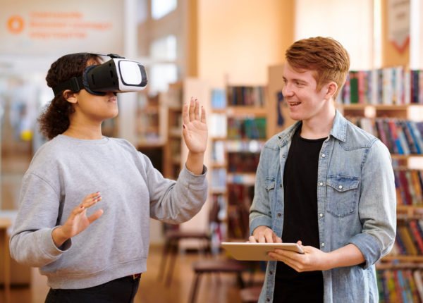 Femme portant un casque de réalité virtuelle à côté d'une autre personne