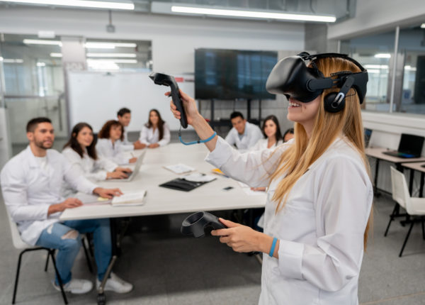 Groupe de personnes en blouse de laboratoire observant une femme avec un casque de réalité virtuelle