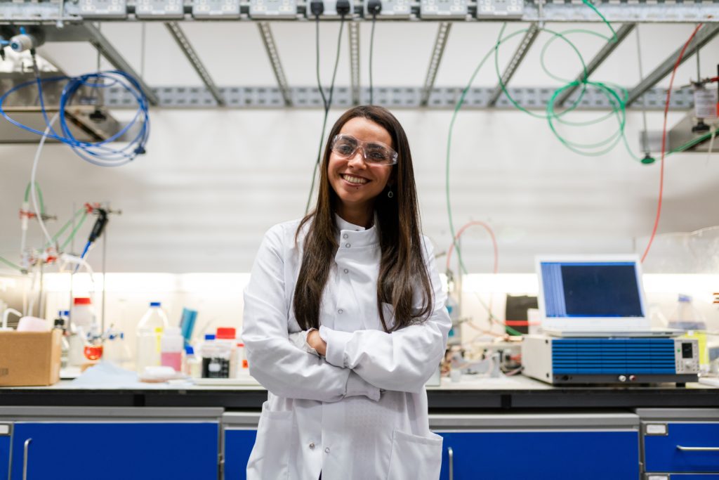 Femme en blouse de laboratoire qui sourit