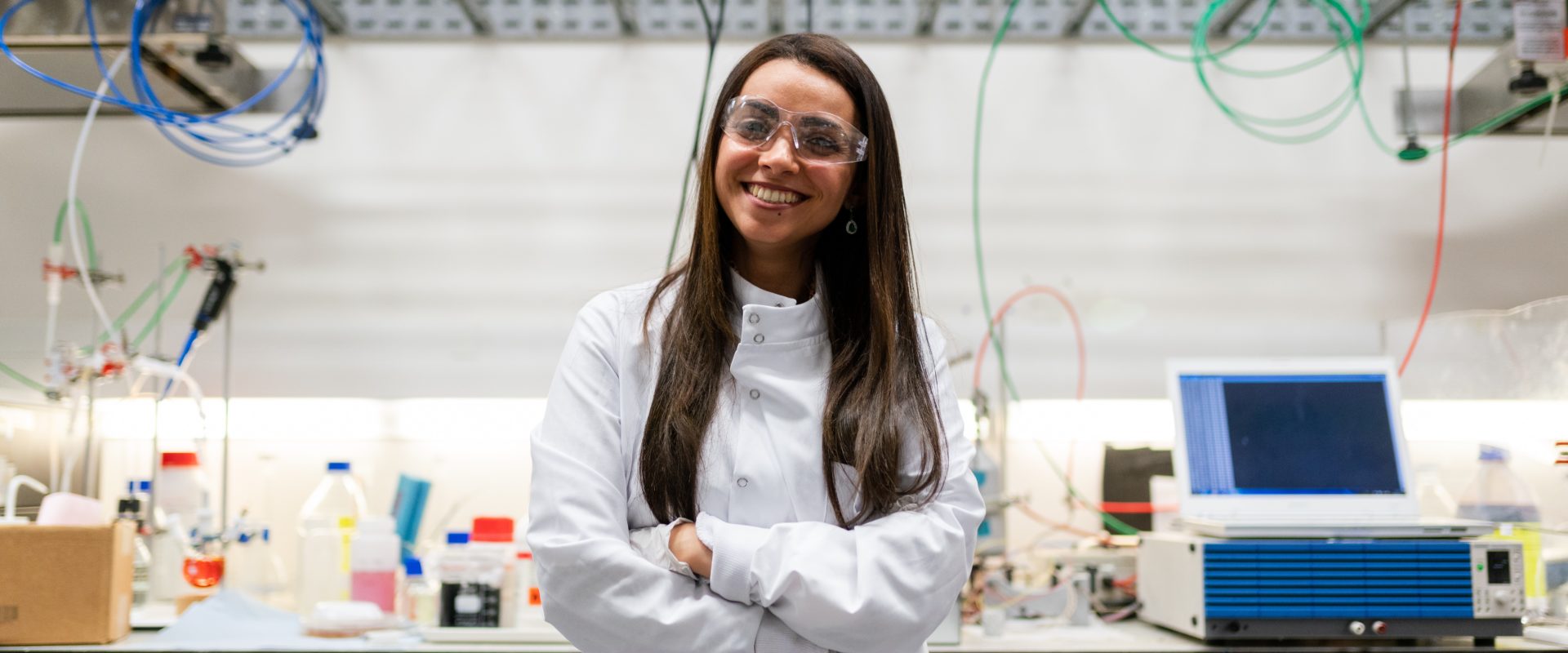 Femme en blouse de laboratoire qui sourit